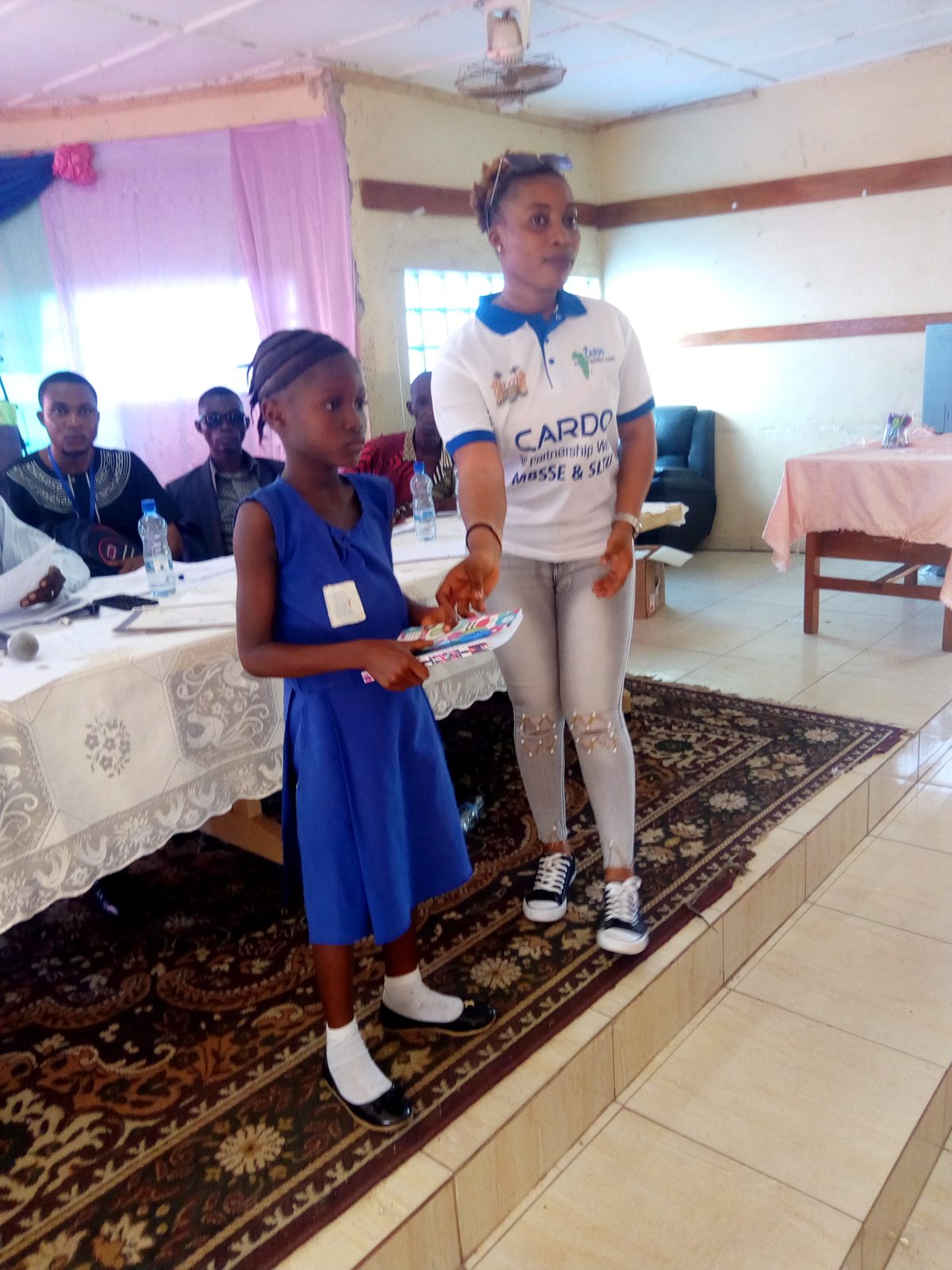A pupil receiving an award from a CARDO team member