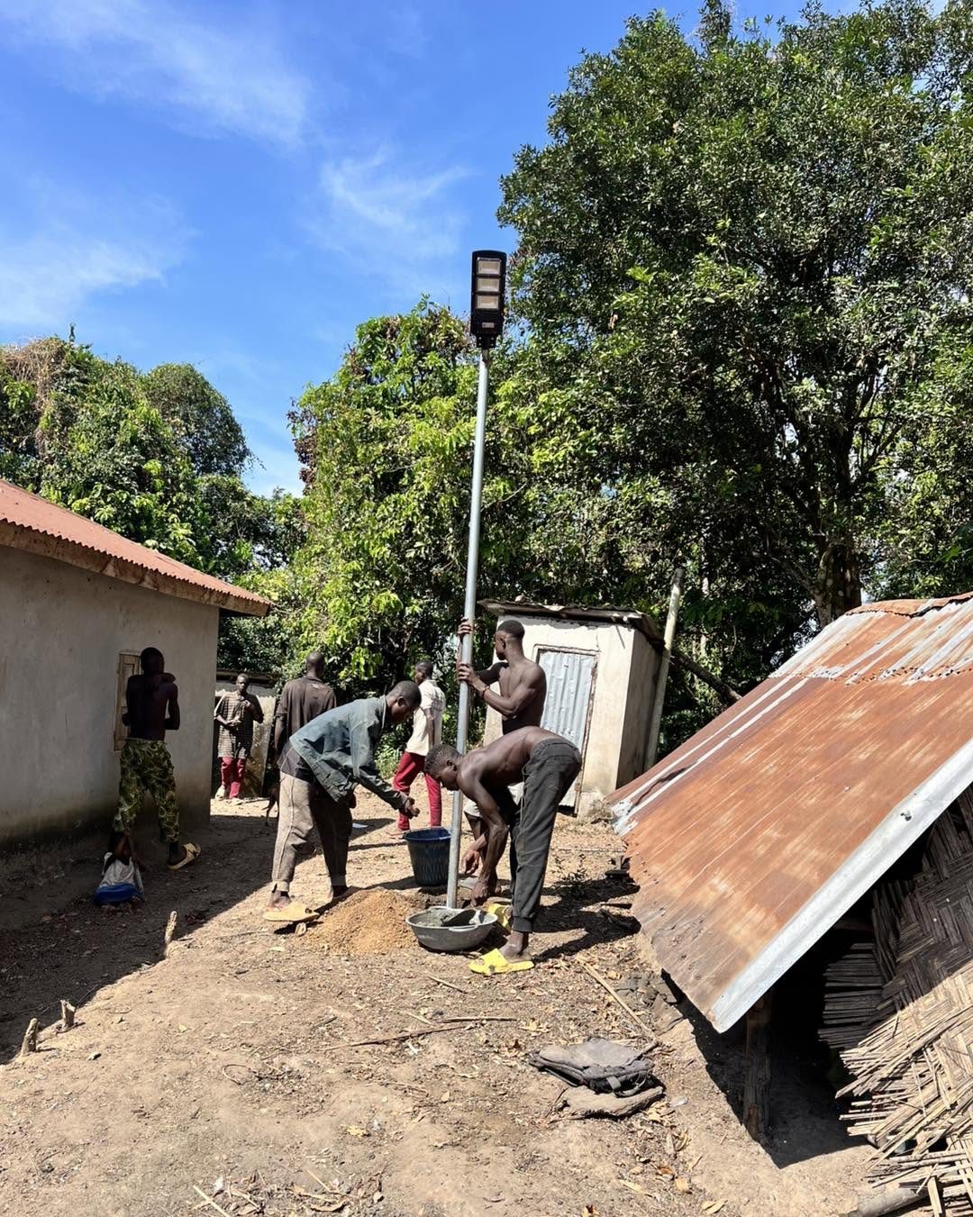 Volunteers and community members installing a solar street light