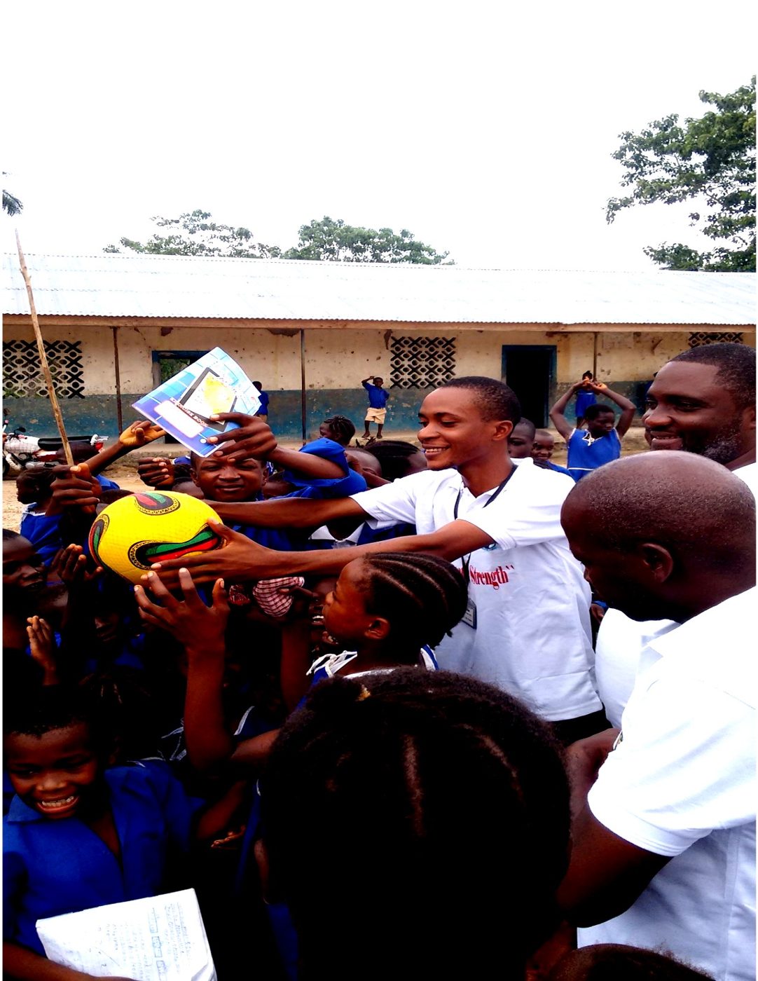 Children gathered indoors as a volunteer hands out materials