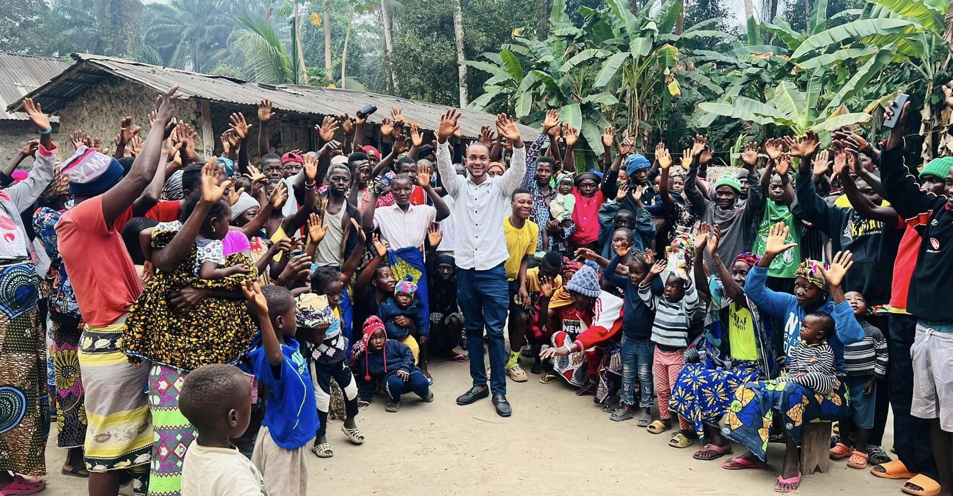 A whole village raising their hands with a CARDO team member