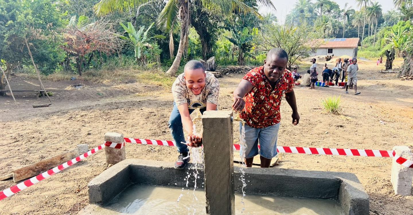 Two men washing their hands at a new water point in Kasimberia