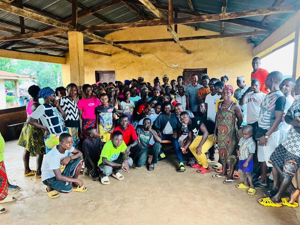 Community members gathered indoors during an agriculture project meeting