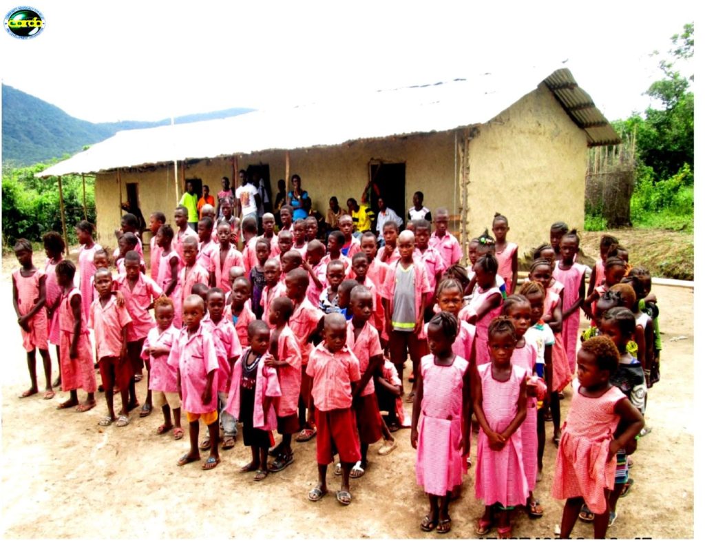 Children and adults gathered outside the community school in Sokoya village