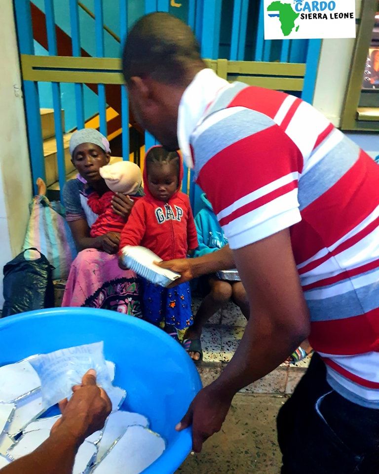 CARDO volunteer serving food during the feeding programme in Freetown