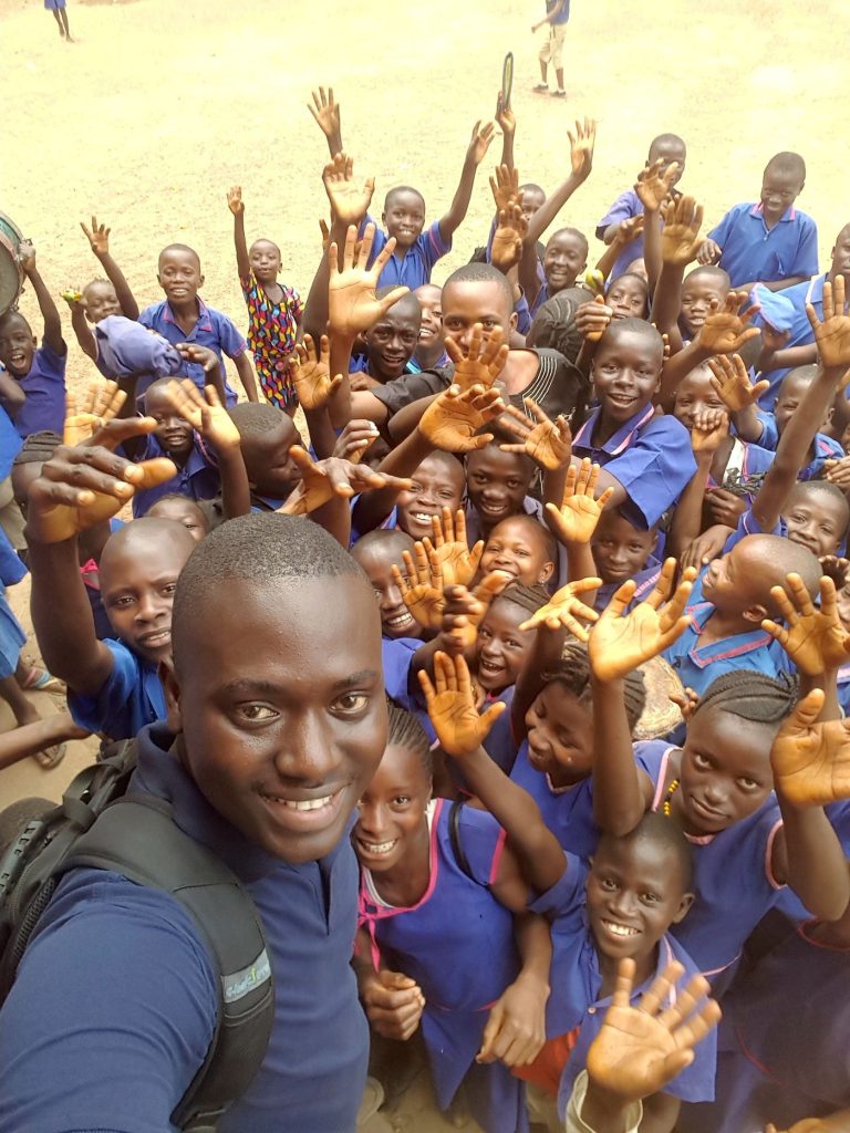 CARDO team member with pupils raising their hands