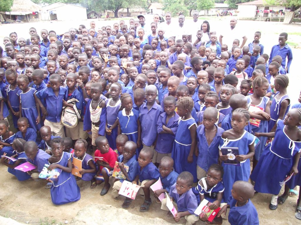 Large group of pupils in blue uniforms gathered outdoors at a CARDO school event