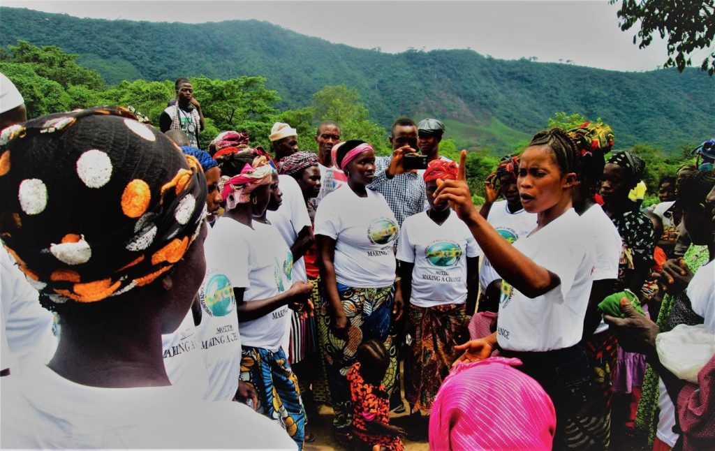 Women and community members listening during a CARDO sensitisation session