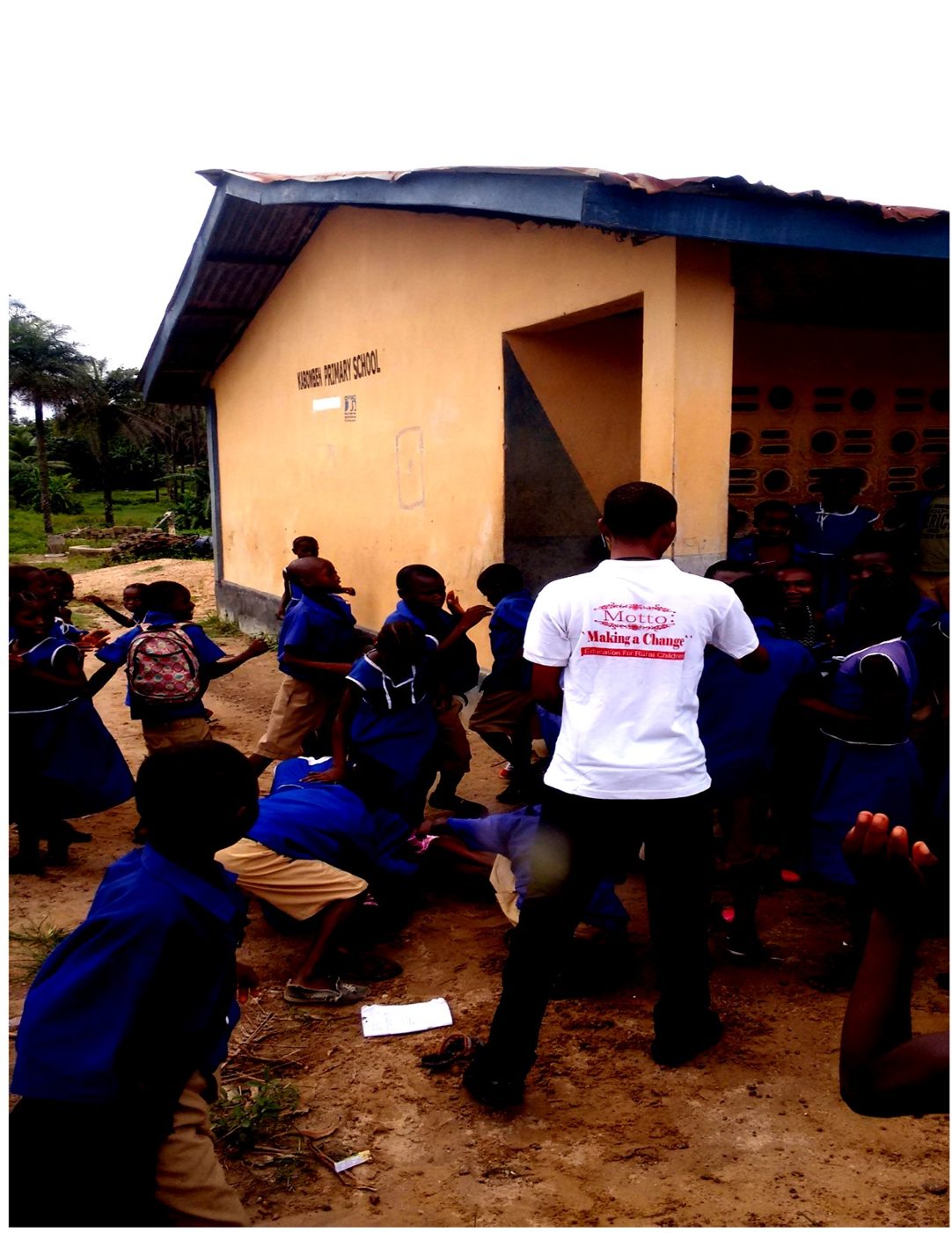 A CARDO volunteer distributing school materials to a group of pupils